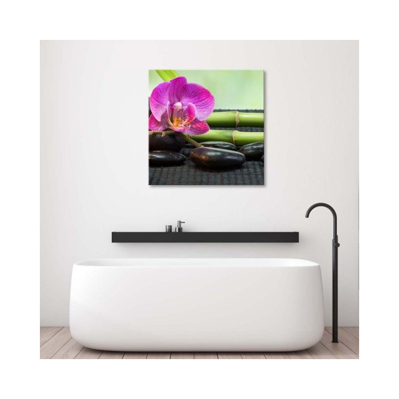 Leinwandbild - Blühende Orchidee auf schwarzen Steinen | Feeby