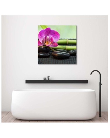 Leinwandbild - Blühende Orchidee auf schwarzen Steinen | Feeby